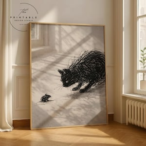 Könnte beinhalten: Ein gerahmter Druck mit einer schwarzen Katze und einer Maus in minimalistischem Stil. Die Katze ist mit strukturierten Linien gezeichnet und bereit, auf die kleine Maus zu springen. Der Druck ist in einem Holzrahmen. Der Text "The Printable Design Studio" befindet sich oben links.