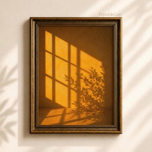 Puede incluir: Una impresión de arte mural rectangular en un marco de tono bronce oscuro. La obra muestra una superficie de pared interior de color amarillo dorado cálido iluminada por la luz solar, proyectando sombras de ventana y hojas.