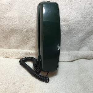 May include: A dark green wall-mounted telephone handset with a glossy finish and a matching coiled black cord. The handset is rectangular with rounded edges and features a smooth, solid surface without any visible buttons or dial pad on the front.