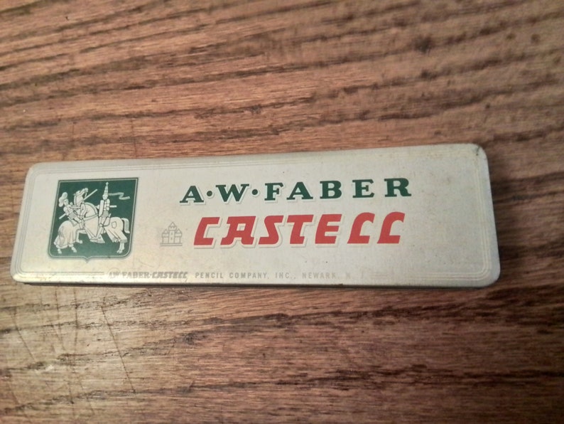 May include: A white metal tin with green and red lettering. The tin says "A.W. FABER CASTEEL" and "FABER-CASTEEL PENCIL COMPANY, INC., NEWARK, N.J.". A knight on horseback is pictured in the upper left corner.