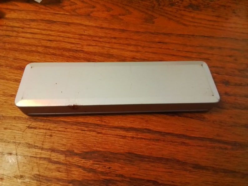 May include: A white rectangular tin box with a slightly worn surface.