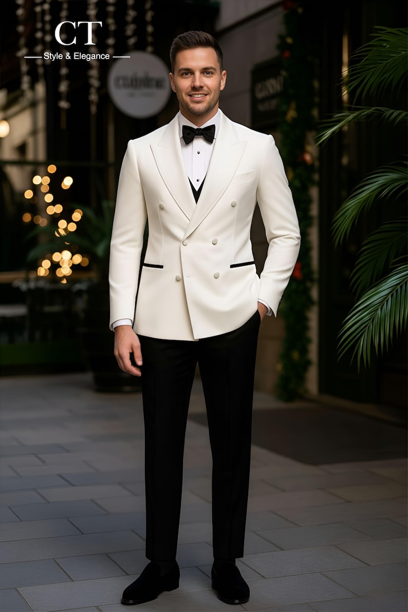 May include: A formal ivory double-breasted suit with black trim, paired with black trousers and a bow tie. The suit features a black vest and a white dress shirt. The image includes the text "CT Style & Elegance".