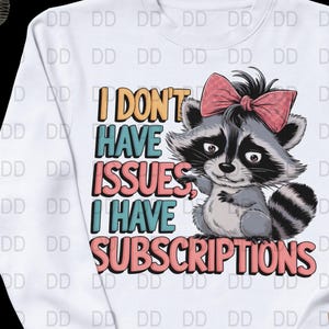 May include: White sweatshirt with a graphic of a raccoon wearing a pink bow. The text on the sweatshirt reads "I don't have issues, I have subscriptions."