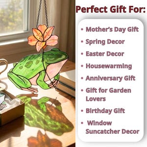May include: A stained glass frog suncatcher with a flower, hanging from a chain. The frog is green with pink accents, and the flower is orange. The text reads "Perfect Gift For: Mother's Day Gift, Spring Decor, Easter Decor, Housewarming, Anniversary Gift, Gift for Garden Lovers, Birthday Gift, Window Suncatcher Decor."