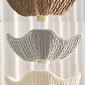 Pode incluir: Tr&ecirc;s ninhos de beb&eacute; de malha de diferentes cores. Os ninhos t&ecirc;m a forma de uma tigela e apresentam um padr&atilde;o de malha de cabo. As cores s&atilde;o bege, cinza claro e branco.