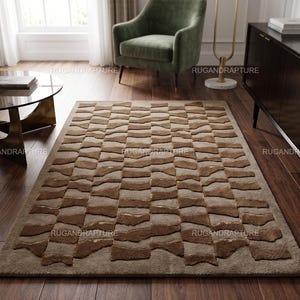 May include: A rectangular area rug with a geometric pattern of alternating light and dark brown rectangular shapes. The rug is on a hardwood floor, with a green armchair and a dark cabinet in the background. The text "RUGANDRAPTURE" is visible.