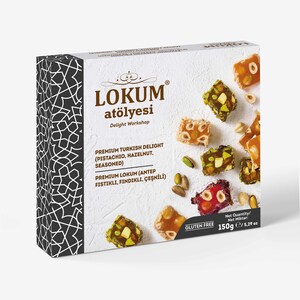 Puede incluir: Una caja blanca de delicias turcas Lokum Atölyesi. La caja presenta un diseño geométrico en blanco y negro en el lado izquierdo. La caja contiene trozos de delicias turcas con pistachos y avellanas. La caja también indica "Sin gluten" y el peso neto es de 150g.