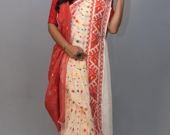 May include: A white and red saree with a floral pattern. The saree has a red border with intricate designs. The saree is draped over a woman's body.