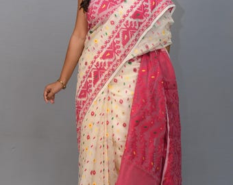 May include: A white and pink saree with a geometric pattern. The saree has a pink border and a white body with a pink and white geometric pattern.