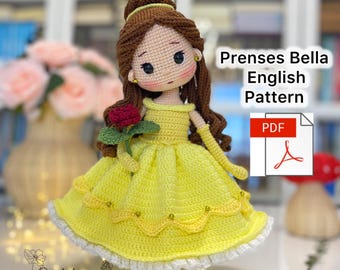 May include: Crocheted doll of a princess in a yellow dress, holding a red rose. The doll has brown hair and is wearing gold earrings. The text "Prenses Bella English Pattern" is visible on the right side of the image, along with a PDF icon.
