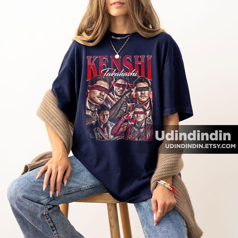 K&ouml;nnte beinhalten: Marineblaues T-Shirt mit einem Retro-Design. Der Text "Kenshi Takahashi" ist rot, und die Grafik zeigt Portr&auml;ts von Personen mit Augenbinden. Die Etsy-Shop-URL ist unten rechts sichtbar.