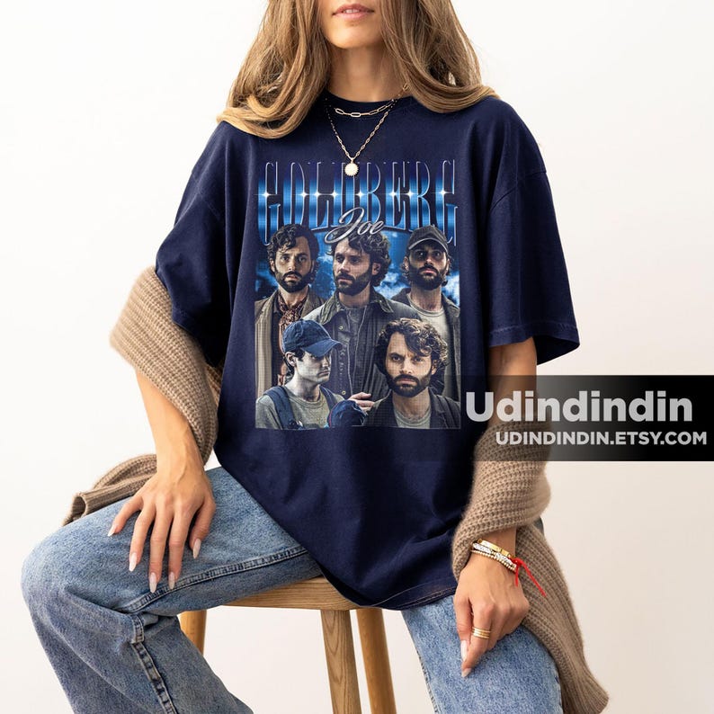 Puede incluir: Una camiseta azul marino con un gr&aacute;fico de estilo vintage del elenco del programa de televisi&oacute;n "The Goldbergs" con el texto "Goldberg Joe" impreso en la parte delantera.
