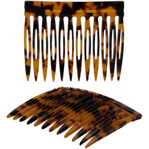 May include: Two tortoiseshell hair combs. The top comb is straight and the bottom comb is curved.