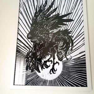 Op de afbeelding: Zwart-witte linosnede van een raaf met gespreide vleugels, die naar een zon vliegt. De raaf bevindt zich in het midden van de afbeelding, de zon op de achtergrond. De print is ingelijst in een wit frame.
