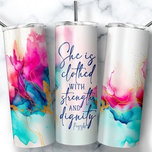 May include: A white stainless steel tumbler with a pink, blue, and gold abstract watercolor design. The tumbler has the text "She is clothed with strength and dignity Proverbs 31:25" printed on it.