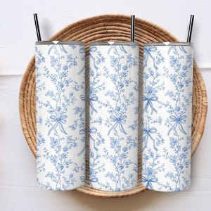 Op de afbeelding: Set van drie keramische mokken met een gespikkelde, matte afwerking. De mokken zijn in crème, lichtgrijs en donkergrijs. Elke mok heeft een eenvoudig, minimalistisch ontwerp, perfect voor koffie of thee. De mokken zijn gestapeld, ongeveer 10 cm hoog.