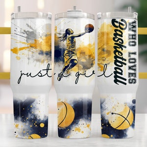 May include: A white tumbler with a yellow lid and handle. The tumbler has a watercolor design of a basketball player with the text "Who Loves Basketball" and "Just a girl" on the sides.