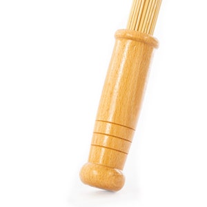 K&ouml;nnte beinhalten: Ein Holzgriff mit einem Satz d&uuml;nner Holzst&auml;be, die am Ende befestigt sind. Der Griff ist hellbraun und hat eine glatte Oberfl&auml;che.