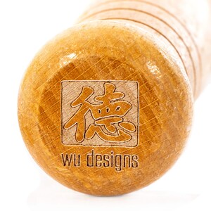 K&ouml;nnte beinhalten: Nahaufnahme eines Nudelholzes aus Holz mit einem quadratischen Design mit chinesischen Schriftzeichen und dem Text "wu designs".
