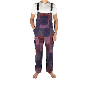 May include: Patchwork dungarees in shades of purple, burgundy, and blue. The bib overalls feature a front pocket and adjustable straps. The trousers have a relaxed fit and cargo pockets. The overall length is approximately 152 cm.