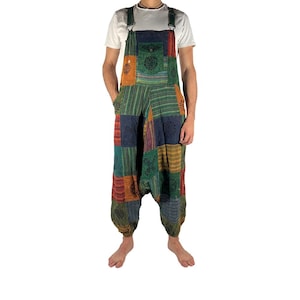 May include: Multi-coloured patchwork dungarees with adjustable straps and pockets. The fabric features a mix of patterned and striped materials in shades of green, orange, blue, and red. The garment has a relaxed fit.