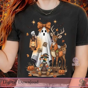 以下が含まれることがあります： ハロウィーンをテーマにしたグラフィックが特徴の黒いTシャツ。デザインには、ランタンを持った幽霊、鹿、アヒルが含まれており、すべて秋の衣装を着ています。カボチャと落ち葉が秋のシーンを完成させます。「Digital Download」の文字が下にあります。