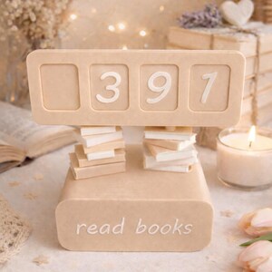 May include: A beige decorative book-shaped object with the text "read books" and the numbers "397" displayed. Small stacks of miniature books are placed below the numbers. The scene includes a lit candle and decorative elements.