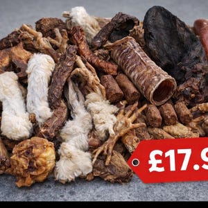 Può includere: Un assortimento di snack per cani di varie forme e colori, tra cui masticabili bianchi, marroni e scuri. Gli snack variano nella consistenza, alcuni appaiono soffici e altri più rigidi. Un'etichetta rossa con il prezzo è visibile.