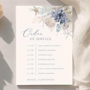 May include: A rectangular wedding program with the words "Order of Service" in elegant script. The top features watercolor illustrations of seashells and coral in shades of blue, beige, and white. The schedule includes times for the ceremony, cocktail hour, and reception.