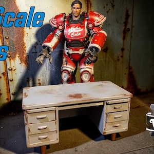 Puede incluir: Una escena de utilería a escala 1/6 con un escritorio de metal desgastado con cajones y una figura de armadura asistida con temática de Fallout roja y blanca. La imagen incluye el texto "1/6 Scale Props" y un logotipo de Vault Craft Creations.