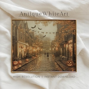 May include: A framed print of a Halloween street scene. The artwork depicts a cobblestone street lined with buildings, lit by streetlights and string lights. Pumpkins and bats are visible. The text "Antique White Art" and "HIGH-RESOLUTION | INSTANT DOWNLOAD" are displayed.