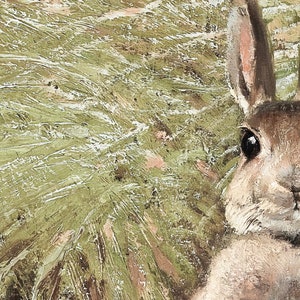 Peut inclure: Gros plan sur le visage d'un lapin brun avec un &oelig;il noir, qui se cache derri&egrave;re un fond textur&eacute; vert et blanc.