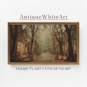 Può includere: Una stampa incorniciata di una scena di Halloween. L'opera raffigura una strada fiancheggiata da alberi, lampioni e lanterne di zucca. Il testo "Antique White Art" è in alto e "FRAME TV ART | FITS UP TO 85" in basso.