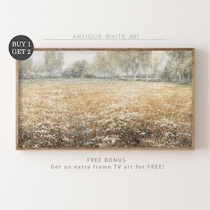 May include: A framed painting of a field of wildflowers with a forest in the background. The painting is in a light wood frame. The text "BUY 1 GET 2" is in a circle in the top left corner of the image. The text "ANTIQUE WHITE ART" is at the top of the image. The text "FREE BONUS Get an extra frame TV art for FREE!" is at the bottom of the image.
