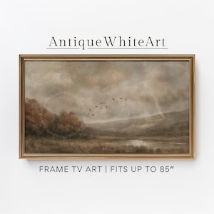 May include: A framed landscape painting in a gold-coloured frame. The artwork shows a tranquil scene with water, trees, and birds flying in a cloudy sky. The text "Antique WhiteArt" is at the top. The text "FRAME TV ART | FITS UP TO 85" is at the bottom.