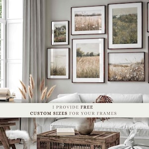 May include: A living room interior with a white couch and a wooden coffee table. The wall is decorated with six framed landscape paintings in various sizes. The text "I provide free custom sizes for your frames" is displayed on a white banner in front of the couch.