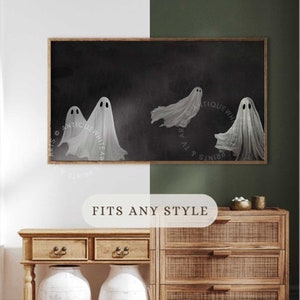 May include: A rectangular framed wall art print featuring four white, translucent ghost figures with dark oval eyes floating against a solid black background. The artwork is displayed in a thin wooden frame, showcasing a dark, atmospheric aesthetic.