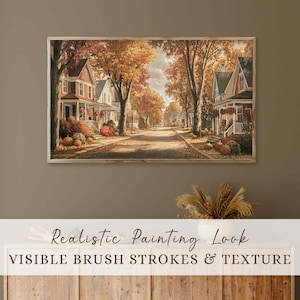 May include: A framed painting shows a street scene with houses and trees in autumnal hues. The artwork has visible brush strokes and texture, with pumpkins and fall foliage adding to the seasonal theme.