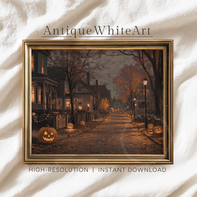 May include: A framed print of a Halloween scene. The artwork depicts a street lined with houses and lit jack-o'-lanterns. The text "Antique White Art" is at the top, and "HIGH-RESOLUTION | INSTANT DOWNLOAD" is at the bottom.