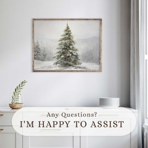 May include: A framed winter landscape painting depicting a snow-covered fir tree in a snowy forest. The artwork has a rustic wooden frame and a muted colour palette of whites, greys, and greens. The text "Any Questions? I'M HAPPY TO ASSIST" is at the bottom.