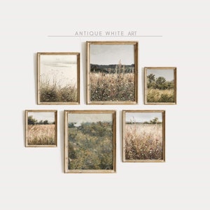 May include: A set of five framed landscape paintings with a rustic, vintage aesthetic. The paintings depict various scenes of fields and meadows with tall grasses and wildflowers. The frames are a light wood colour with a distressed finish.