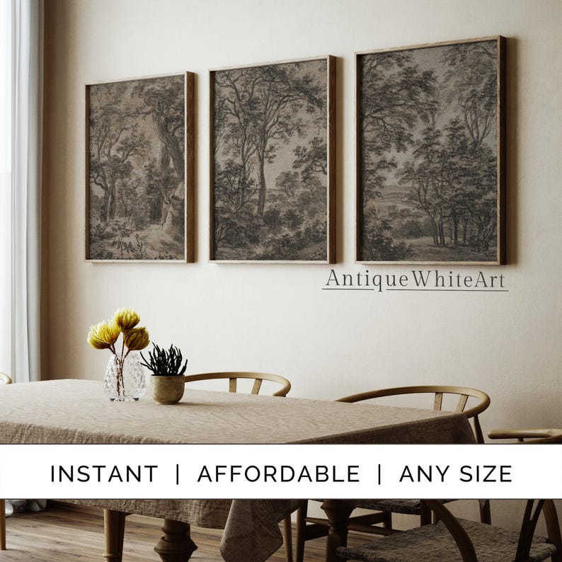 May include: Three black and white framed prints of forest scenes with trees and foliage. The prints are hanging on a light beige wall above a wooden table with a light brown tablecloth. The text "AntiqueWhiteArt" is printed below the prints.