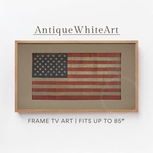 May include: Framed artwork featuring a vintage American flag with red and white stripes and a blue field of white stars. The artwork is set in a brown frame with the text "Antique White Art" and "FRAME TV ART | FITS UP TO 85" displayed.