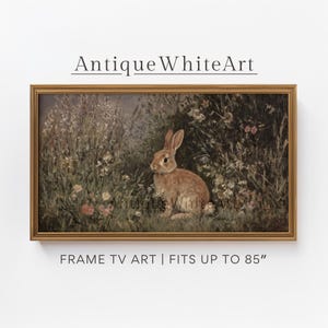 May include: A framed print of a brown rabbit in a field of flowers. The artwork is in a gold frame and has the text "Antique White Art" at the top and "FRAME TV ART | FITS UP TO 85" at the bottom.