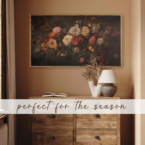 May include: A framed vintage floral painting with a dark background and a variety of pink, red, and white flowers. The painting is in a wooden frame with a gold finish.