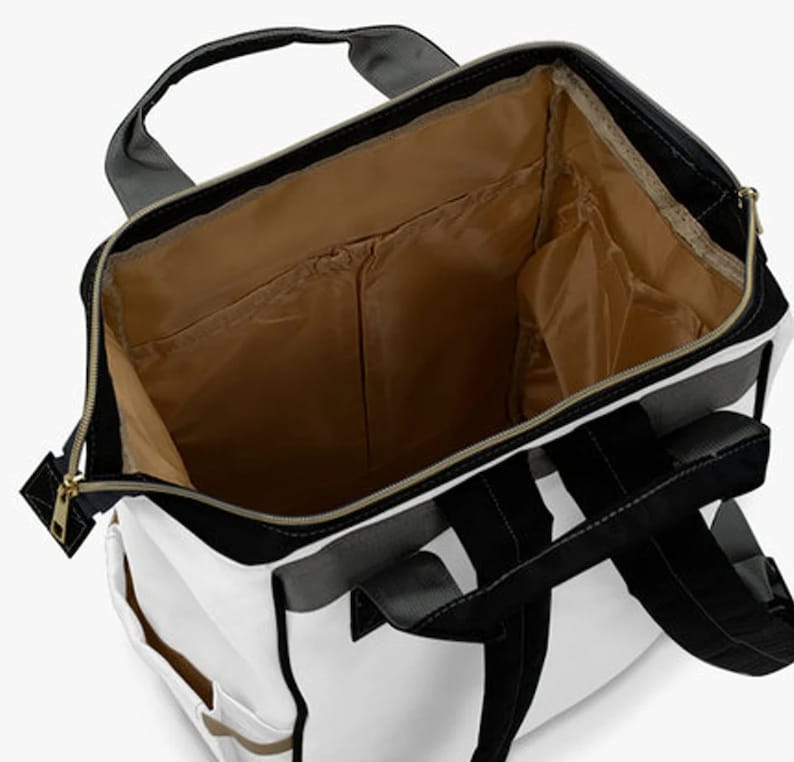 May include: A white backpack with black and gray accents. The backpack has a large main compartment and several smaller pockets. The interior of the backpack is lined with a brown fabric.