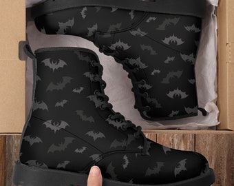 May include: Black leather boots with a grey bat pattern. The boots have laces and a thick sole.