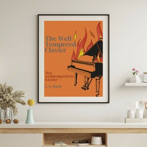 May include: A framed poster with an orange background and a black and white grand piano engulfed in flames. The text on the poster reads "The Well-Tempered Clavier" and "Das wohltemperierte Klavier J.S. Bach".