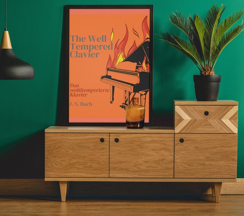 May include: A vintage-style poster with an orange background featuring a black and white illustration of a grand piano with flames behind it. The text on the poster reads "The Well Tempered Clavier" and "Das wohltemperierte Klavier J.S. Bach". The poster is displayed on a wooden shelf with a green wall behind it.