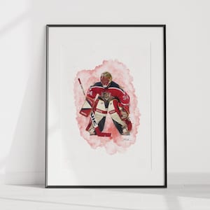 May include: A watercolor painting of a hockey goalie in a red and black uniform, with a white and black helmet, making a save. The goalie is in a crouched position, with their stick in front of them. The painting is set against a pink and white background.